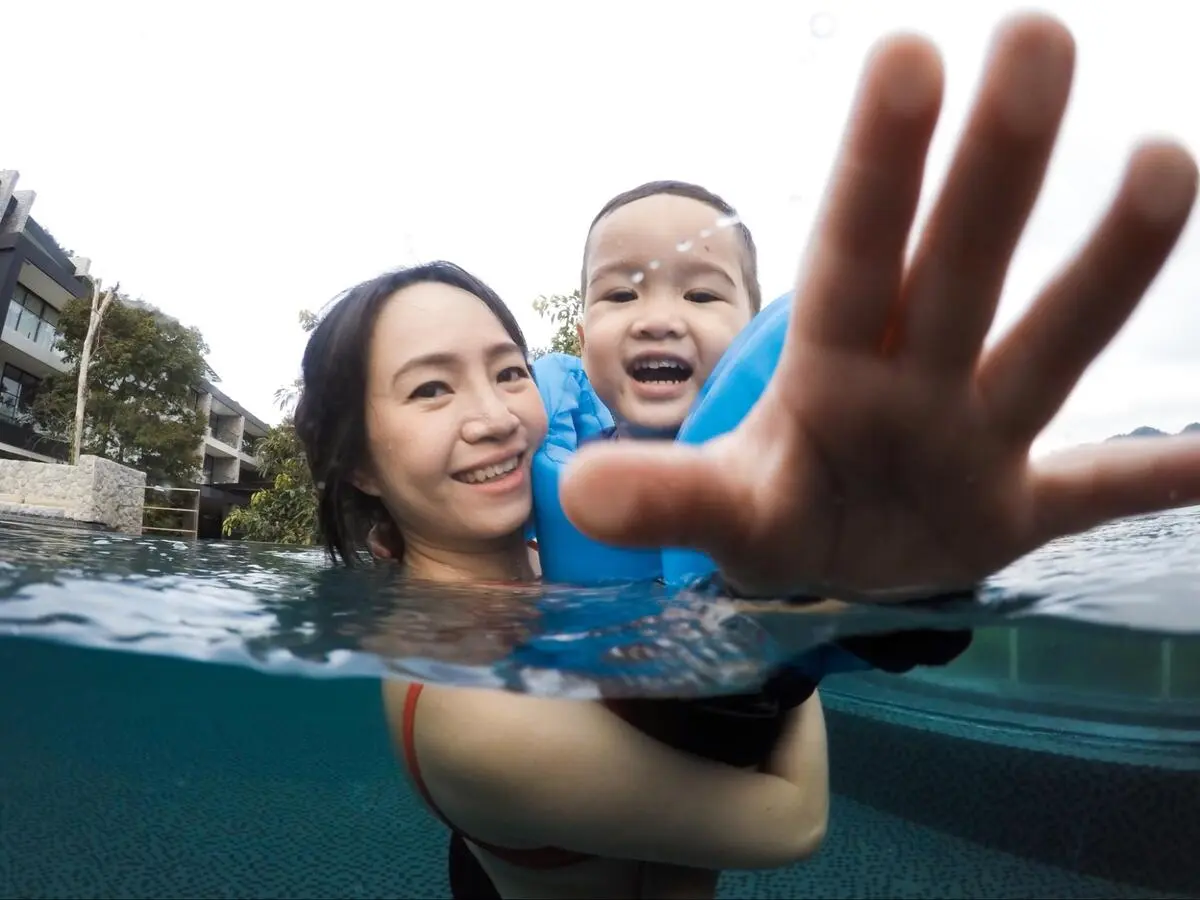 Mother and young child enjoying a swimming lesson together in the pool